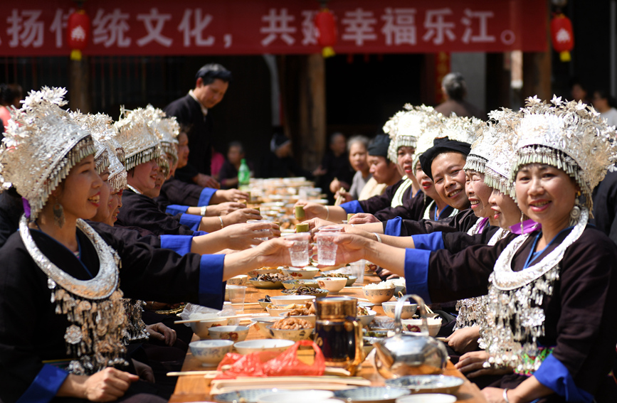侗族群众与游客在共享合拢宴。潘志祥摄