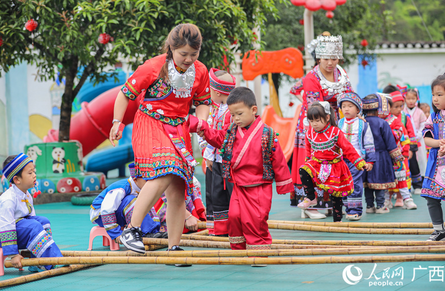 老师和孩子们穿着民族服饰跳竹竿舞。人民网记者 陈燕摄